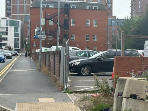a parking lot with cars parked in a city at Joyful Management - Riverview 1 bedroom Apartment 10 min to City Centre in Manchester
