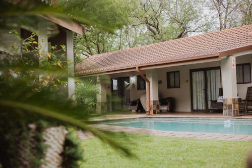 a house with a swimming pool in the yard at Santai guesthouse in Brits