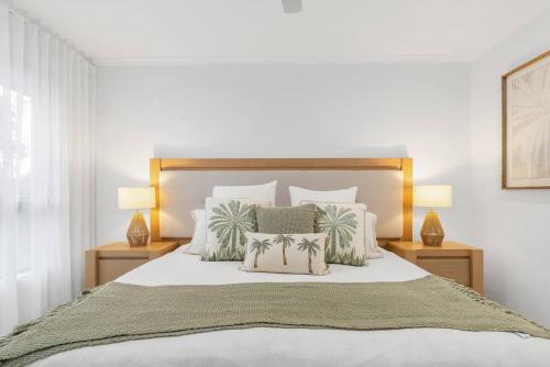 een slaapkamer met een groot bed met twee lampen bij Argentea Cove - Poolside Escape near Palm Cove Beach in Palm Beach