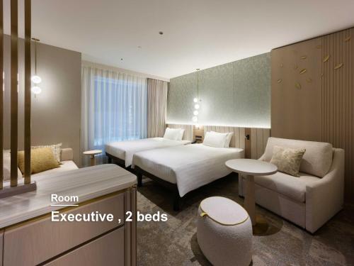 a hotel room with two beds and a couch at Mitsui Garden Hotel Sendai - Reopening on June 14 in Sendai