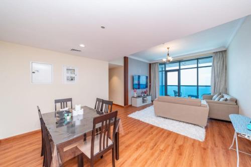 a living room with a table and a couch at Sunset Beach View Holiday Homes in Ajman 
