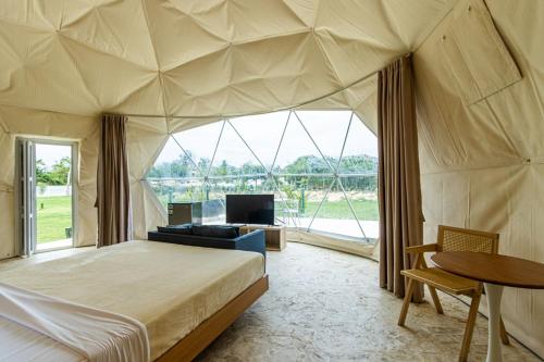 een slaapkamer in een tent met een bed en een tv bij Bubble Glamping King bed, we have a 8 units like this in Laguna del Higüero