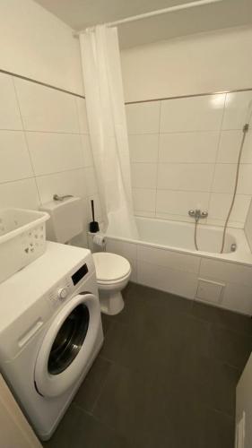 ein weißes Badezimmer mit Toilette und Waschmaschine in der Unterkunft MSC Lampertheim in Lampertheim