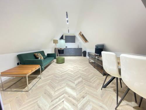 Blindley HeathにあるDippen Hall Signature Apartmentの緑のソファとテーブルのあるリビングルーム