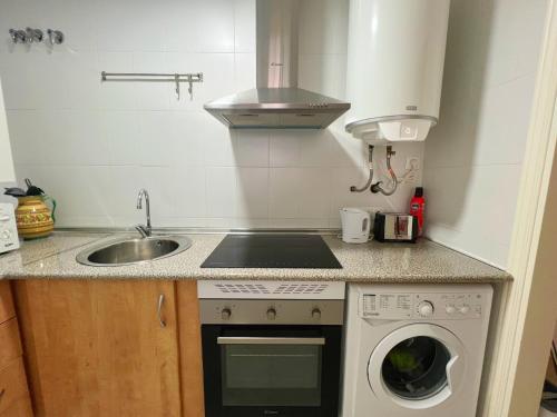 a kitchen with a sink and a washing machine at Loma Blanca by Residea in Manilva