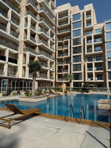 an empty swimming pool with two large apartment buildings at Marjan Escape Studio in Dubai