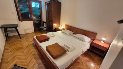 a bedroom with a large bed and a wooden floor at Beachfront House with garden and two terraces in Tisno