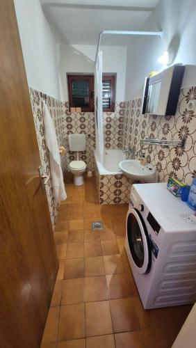a bathroom with a sink and a washing machine at Beachfront House with garden and two terraces in Tisno