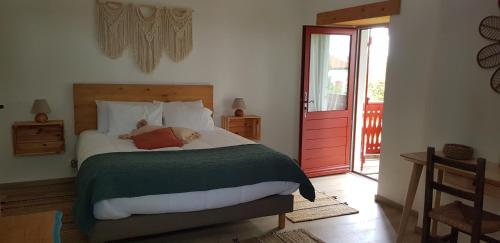 a bedroom with a bed and a red door at Maison d'hôtes MOURENIA Aroue in Aroue