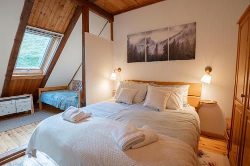 a bedroom with a large bed with towels on it at Apartman Osoj Mrzla Vodica in Mrzla Vodica