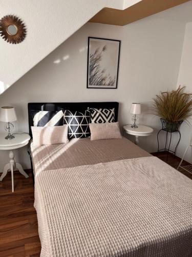 a bedroom with a large bed with two tables at Zapfwerk-Rooms in Großbeeren