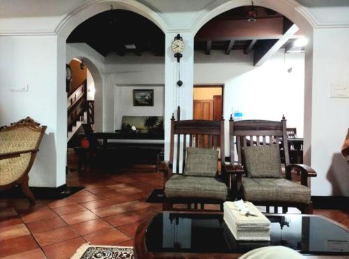 ein Wohnzimmer mit zwei Stühlen und einem Tisch in der Unterkunft Boho Heritage in Kochi in Kochi