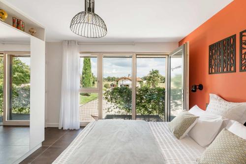 a bedroom with a large bed with an orange wall at La Clé des Chaumes - Chambre d'hôte, Bed and Breakfast avec piscine et bain nordique in Boisset-lès-Montrond