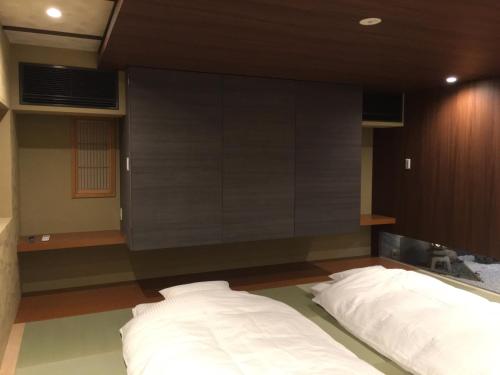 a bedroom with a bed and a large wall at Hananobou Kinkakuji-michi in Kyoto