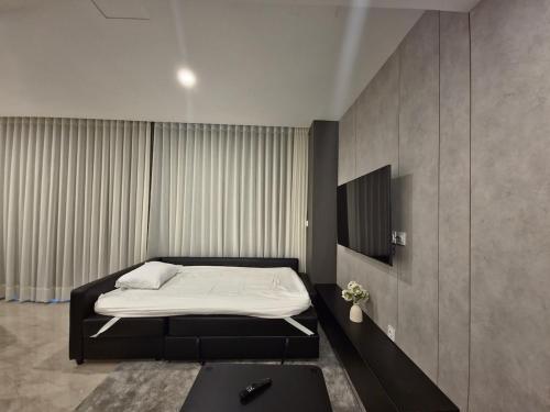 een slaapkamer met een bed en een tv erin bij Modern ZED Apartment Near Pyramids, ZED Park, GEM in Sheikh Zayed