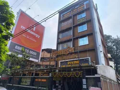 ein hohes Gebäude mit Schildern an der Seite in der Unterkunft Divine Fine Dine in Kalyan