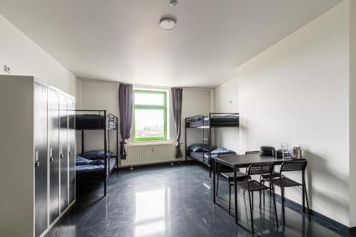 een kamer met een tafel en stoelen en een stapelbed bij Kapselhotel nähe Hauptbahnhof Halle-Saale in Halle an der Saale