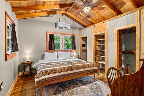 a bedroom with a bed and a ceiling fan at The Elk's Apple Grove, Upper Suite, Real Log Cabin in Maggie Valley