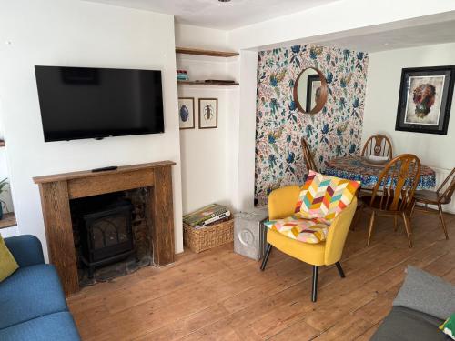 a living room with a tv and a fireplace at North Laine Sunny Cottage - PARKING available in Brighton & Hove