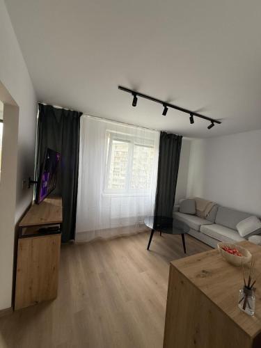 a living room with a couch and a tv in it at Ďumbierska Sásová Apartment in Otilia