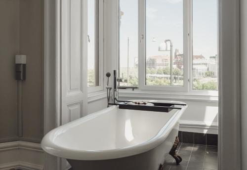 a white bath tub in a room with a window at TwentySix in Malmö
