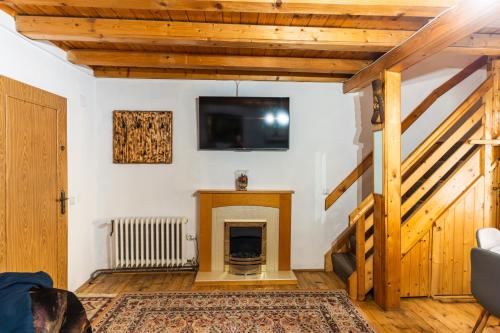 a living room with a fireplace and a flat screen tv at Panoramic Belis Fantanele in Beliş