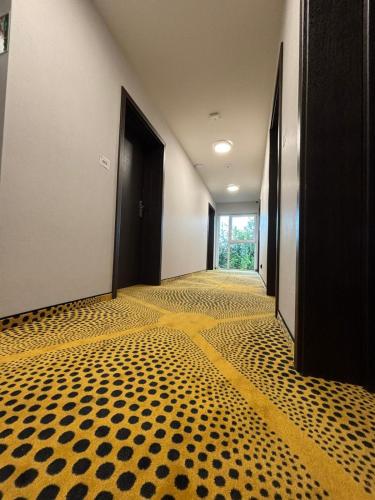 a hallway with black doors and a yellow and black floor at Eclipse Budget Rooms in Domasław