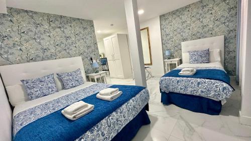 Un dormitorio con dos camas con sábanas azules y blancas. en Bety Dreams Apartments, en Madrid