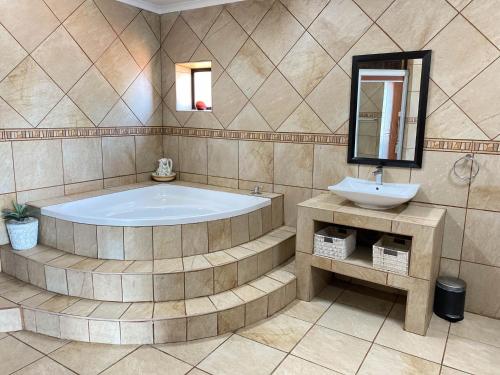 een grote badkamer met een bad en een wastafel bij The Albatros Guesthouse in Margate