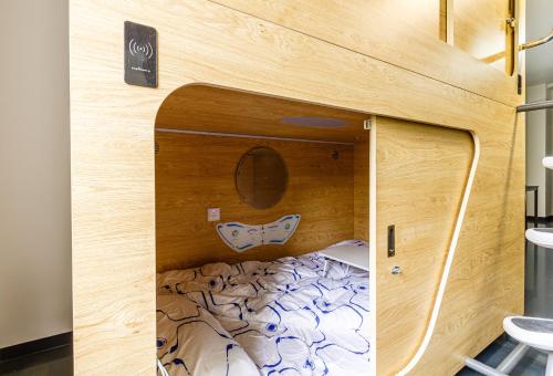 een kleine slaapkamer met een bed in een houten muur bij Kapselhotel nähe Hauptbahnhof Halle-Saale in Halle an der Saale