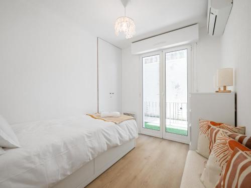 a white bedroom with a bed and a window at Le Cocon - 5 min to Monaco - Ideal couple or business - Free private parking - Near events - Terrace and balcony - Premium services in Fontvieille