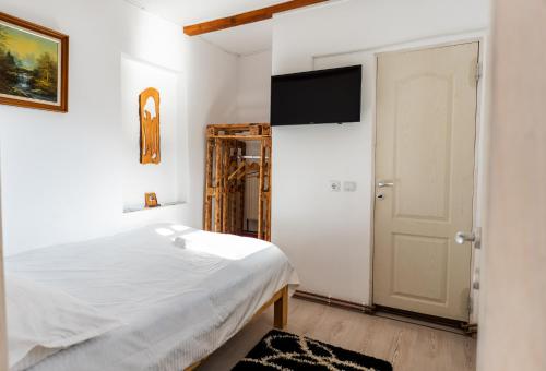 a bedroom with a bed and a flat screen tv at Panoramic Belis Fantanele in Beliş