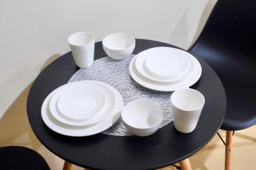 a black table with white plates and cups on it at Urban Oasis in Cagayan de Oro City in Cagayan de Oro