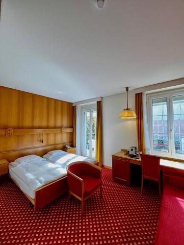 a bedroom with a bed and a desk and chairs at Elite in Lausanne