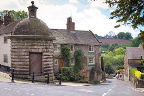 an old stone building with a large door on a street at The Stables in Alton