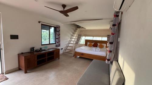 1 dormitorio con cama y escalera en Champions Ranch, en Bāgalūr