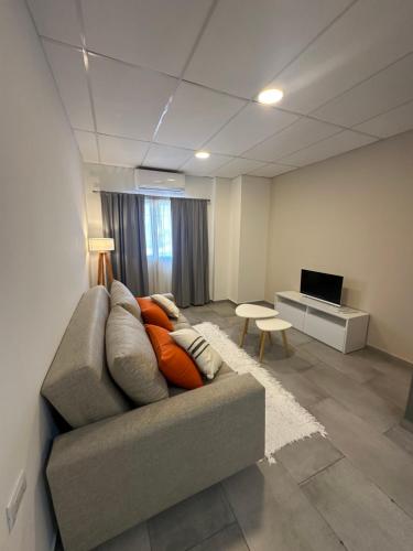 een woonkamer met een bank en een televisie bij Apart Hotel Concepcion in Concepción