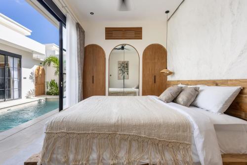 ein Schlafzimmer mit einem großen Bett und einem Pool in der Unterkunft Villa Marcel Premium by Tofino Villas in Uluwatu