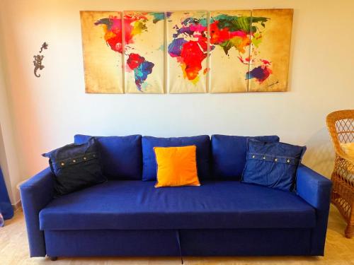 a blue couch with an orange pillow in a living room at Loma Blanca by Residea in Manilva