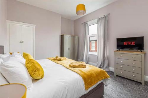 Un dormitorio con una cama blanca con una manta amarilla. en Carnarvon Stays - 2 bed home, en Preston