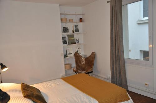 ein Schlafzimmer mit einem Bett und einem Fenster in der Unterkunft CAEN : appartement Cosy hyper centre historique in Caen