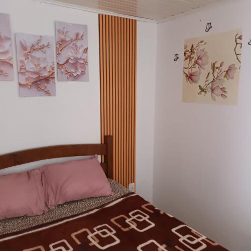 1 dormitorio con 1 cama y 3 cuadros en la pared en Pousada da Maria Guapa, en São Gabriel