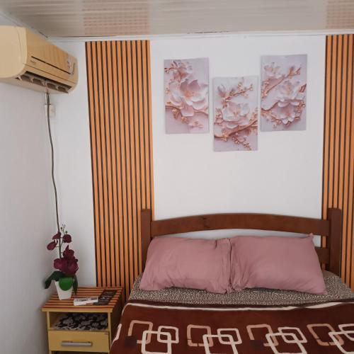 a bedroom with a bed with posters on the wall at Pousada da Maria Guapa in São Gabriel