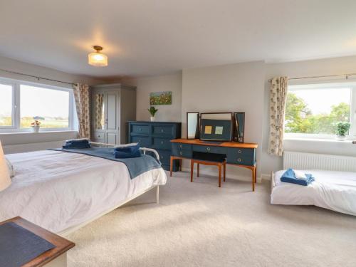 InskipにあるBrook Houseのベッド、テレビ、机のある寝室