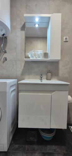 a bathroom with a white sink and a mirror at Apartman Blue in Subotica