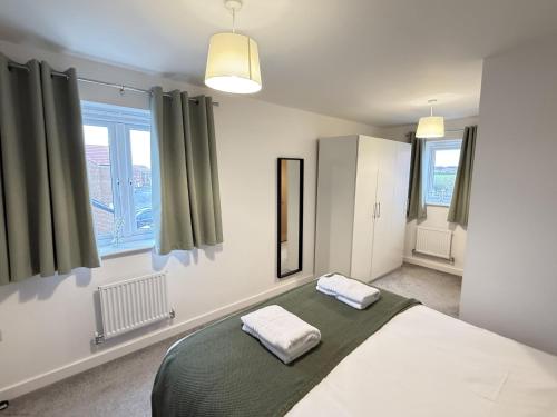 une chambre avec un lit avec deux serviettes dessus dans l'établissement Cayton Bay Cottage, à Cayton