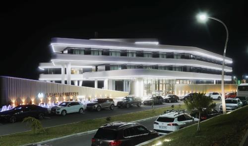 ein Gebäude, vor dem nachts Autos geparkt sind in der Unterkunft Elania Resort & Spa in Cluj-Napoca