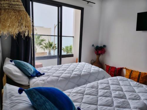 a large bed in a room with a window at Mira bay surf house in Imsouane