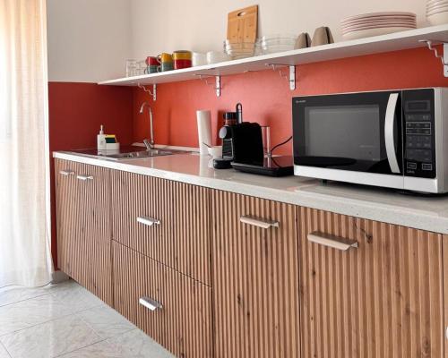 a microwave oven sitting on a counter in a kitchen at Be Your Home - Cruise Stop Guest House in Civitavecchia