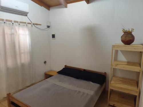 een kleine slaapkamer met een bed en twee planken bij Lo de Alicia in Candelaria